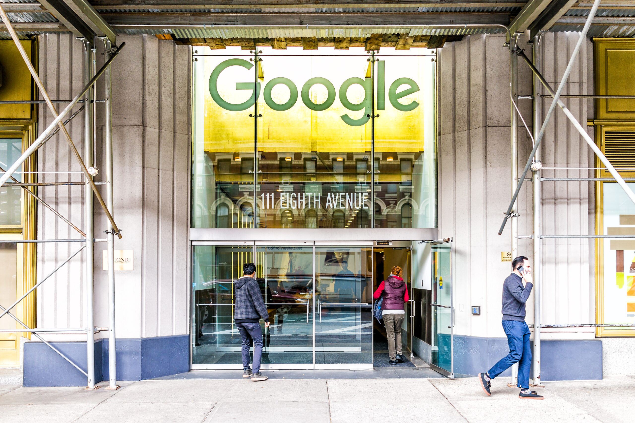 New York City, USA - October 30, 2017: Google company office green sign in downtown lower Chelsea neighborhood district Manhattan NYC, people entering, exiting doors entrance